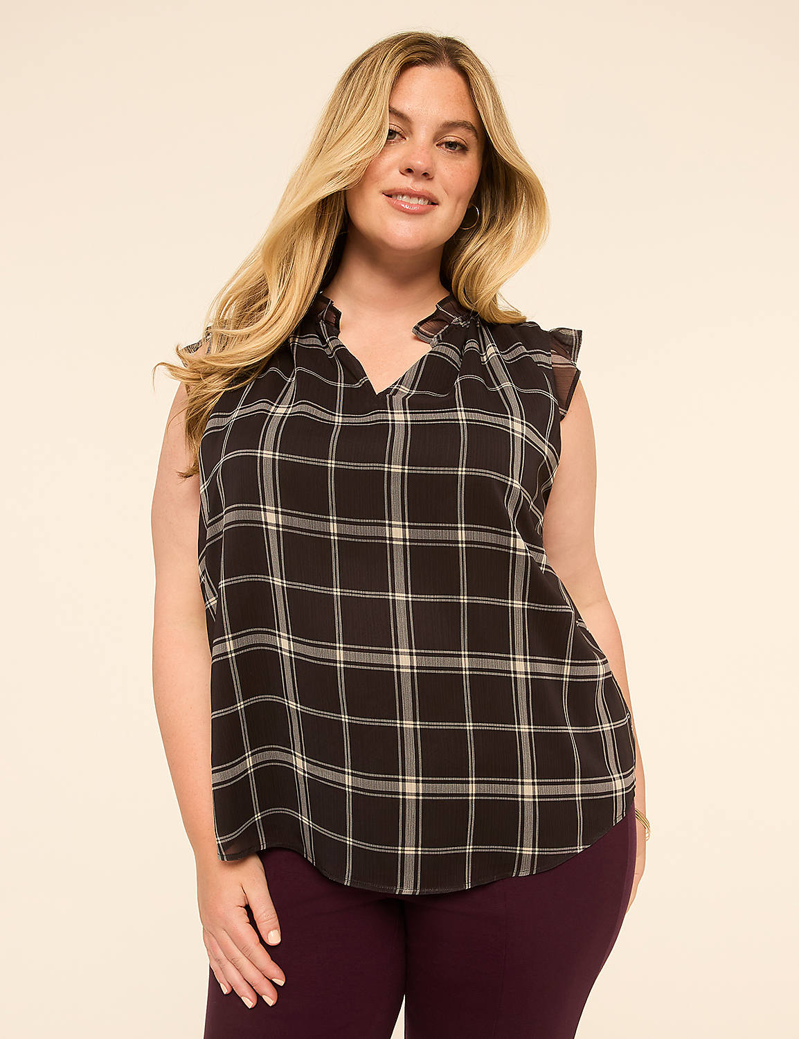 A woman with blonde hair and a plaid blouse stands against a plain, light-colored background. Product Image 1