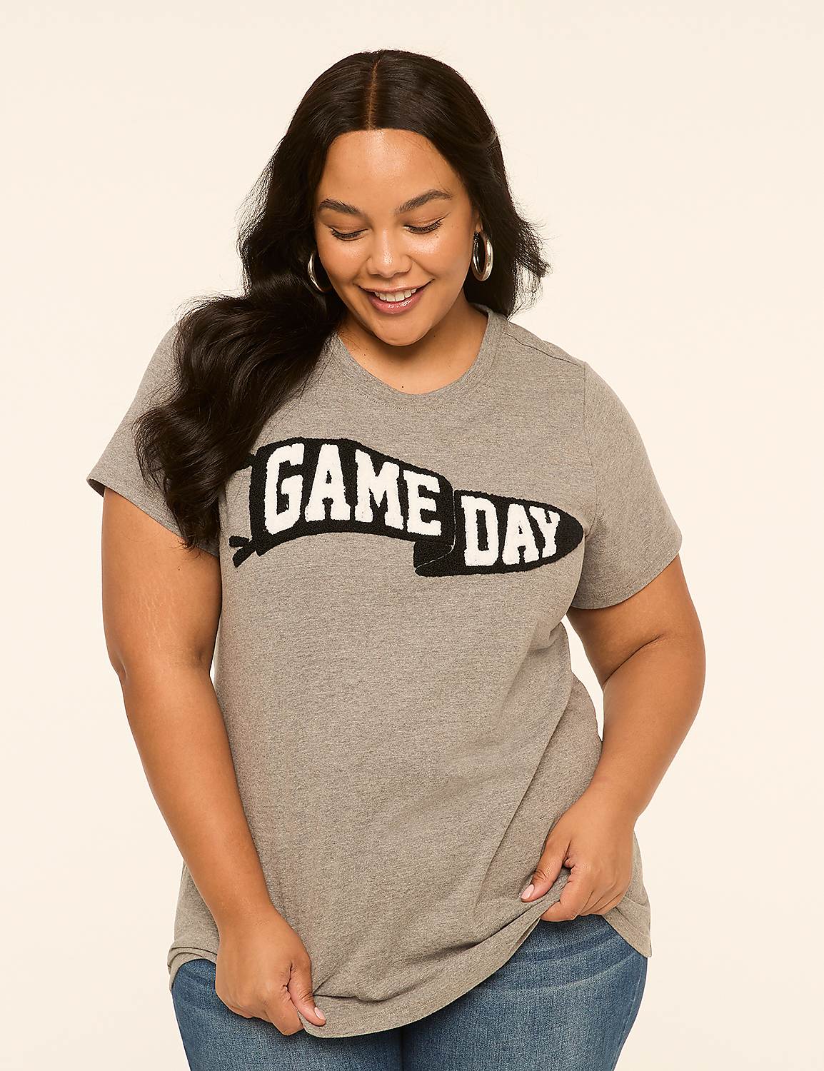 A smiling woman in a gray "GAME DAY" t-shirt stands against a plain, light-colored background. Product Image 1