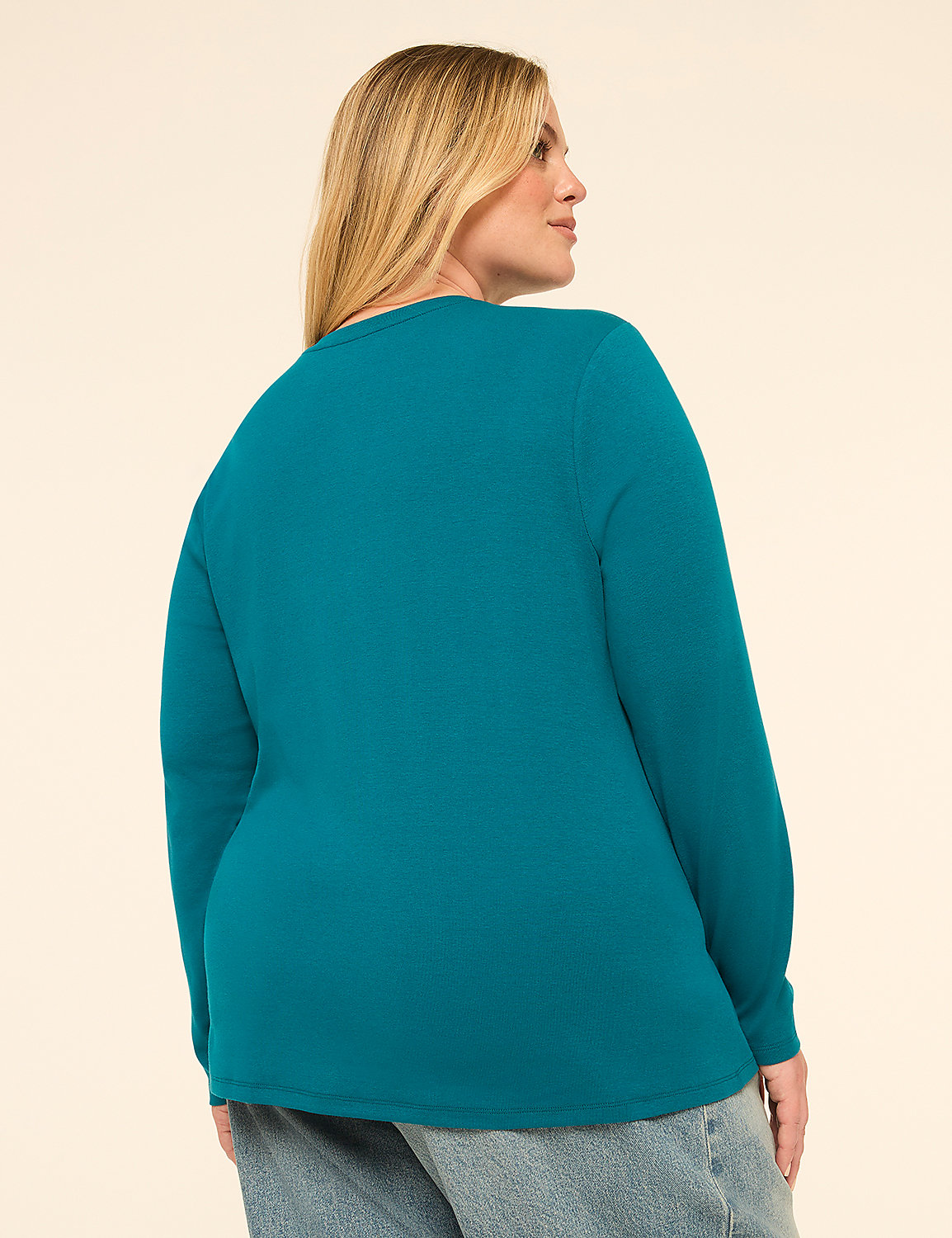 A woman in a teal long-sleeved shirt and jeans stands against a plain, light-colored background. Product Image 2