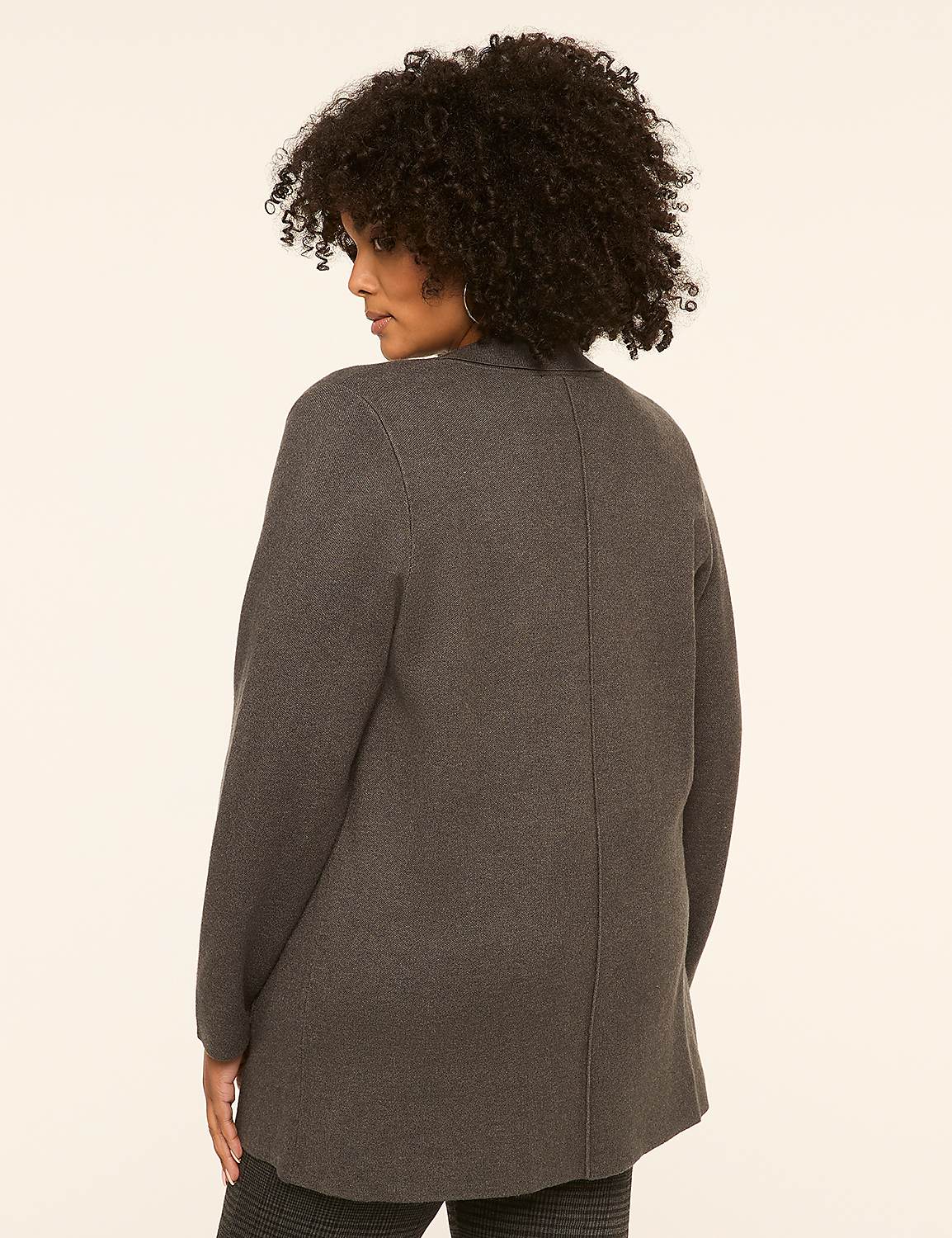 A woman with dark, curly hair stands facing away from the camera in a charcoal gray cardigan and patterned pants against a plain, light background. Product Image 2