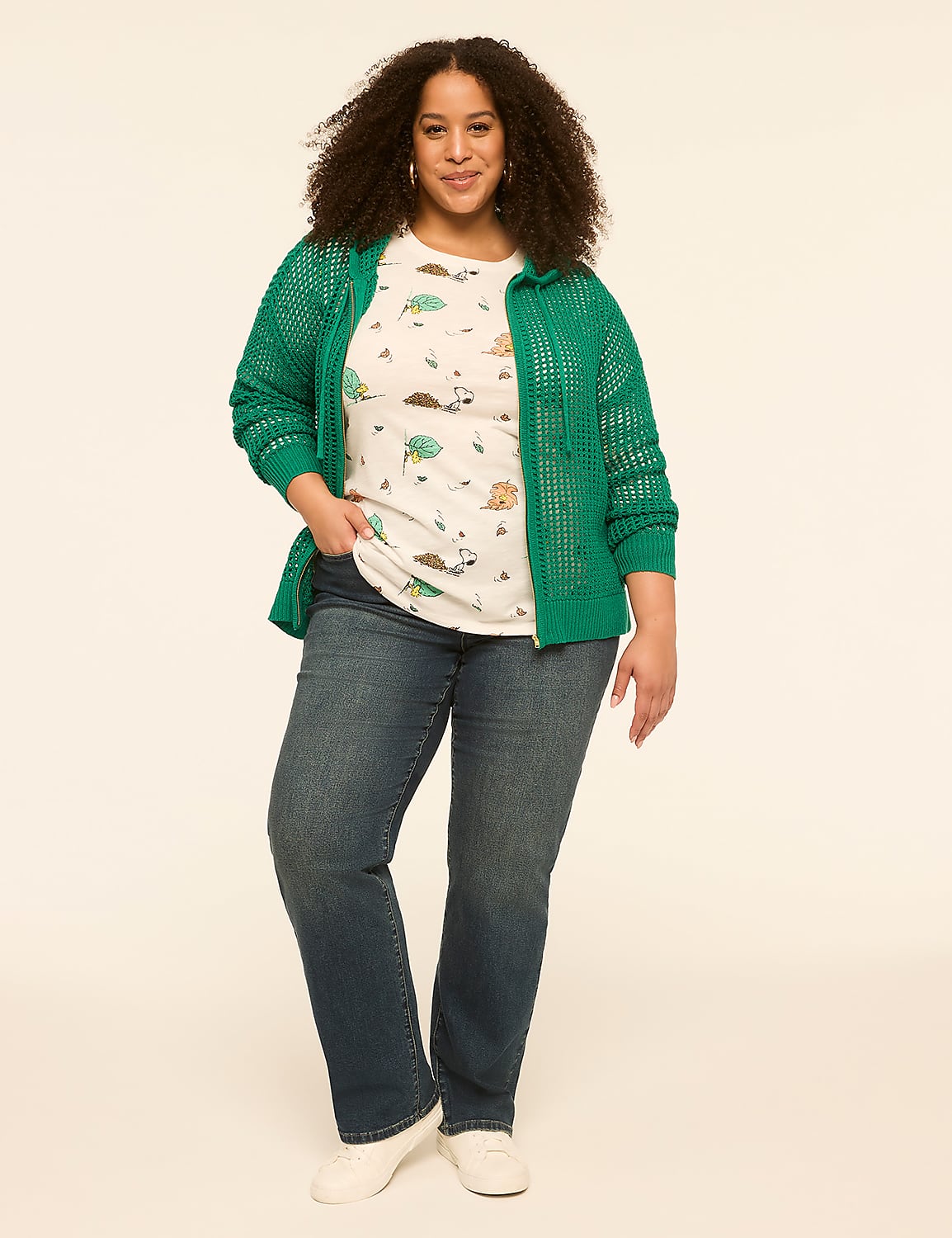 A woman in a green cardigan and patterned t-shirt stands against a plain, light-colored background. Product Image 3