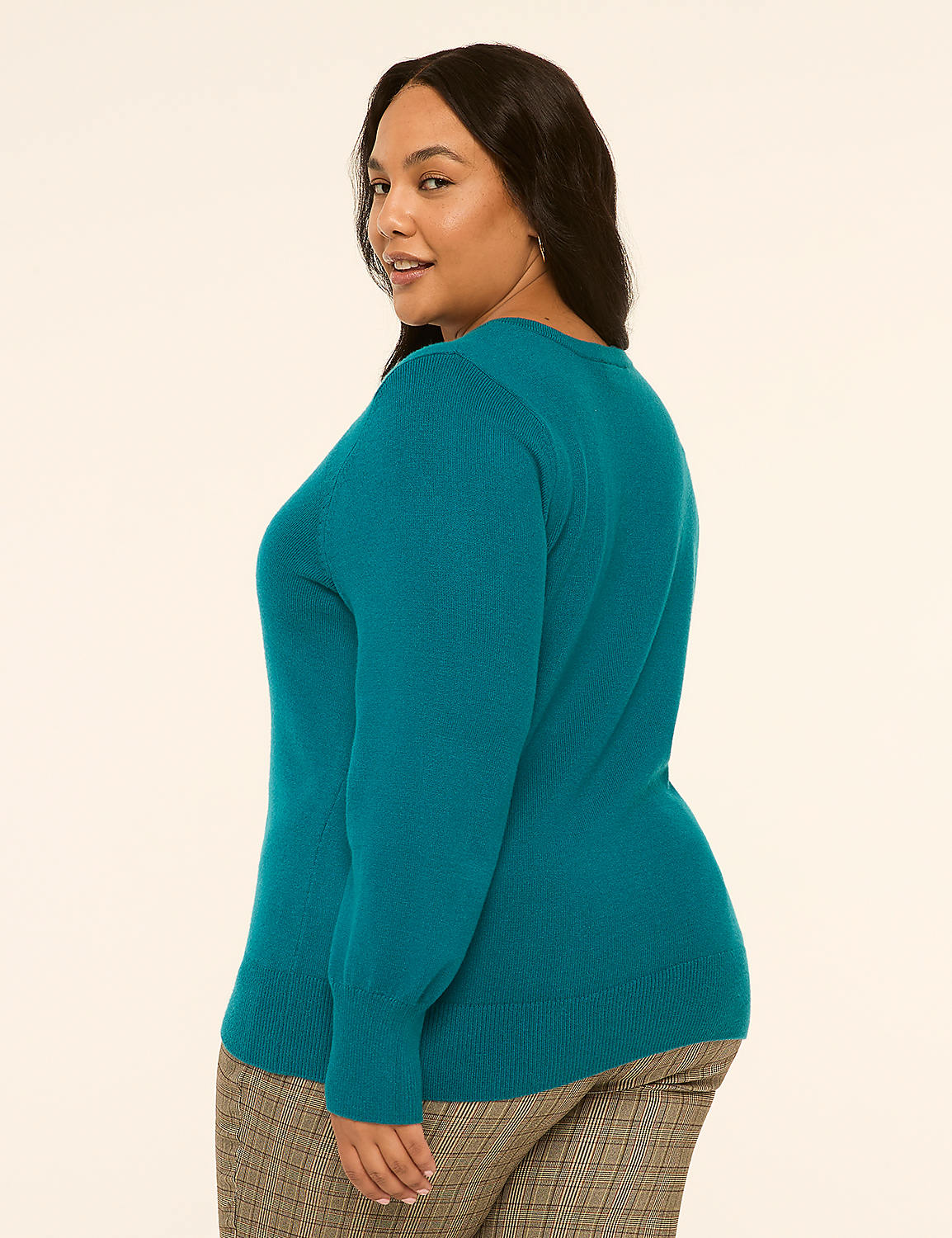 A woman in a teal sweater and plaid pants stands against a plain, light-colored background. Product Image 2