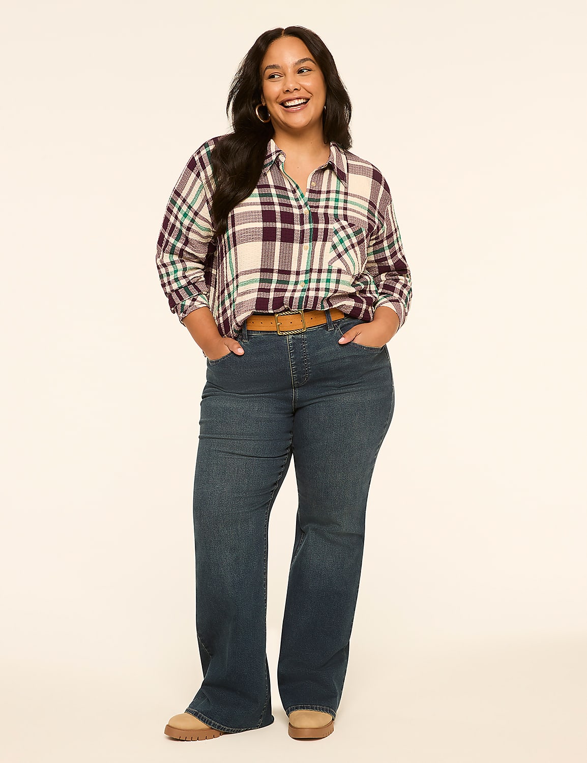 A smiling woman in a plaid shirt and jeans stands against a plain, light-colored background. Product Image 3