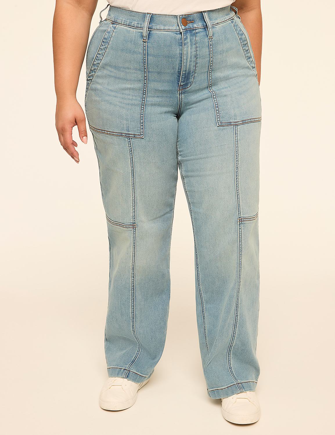 A person stands in light-wash denim jeans with prominent stitching and large front pockets, against a plain, light-colored background. Product Image 1