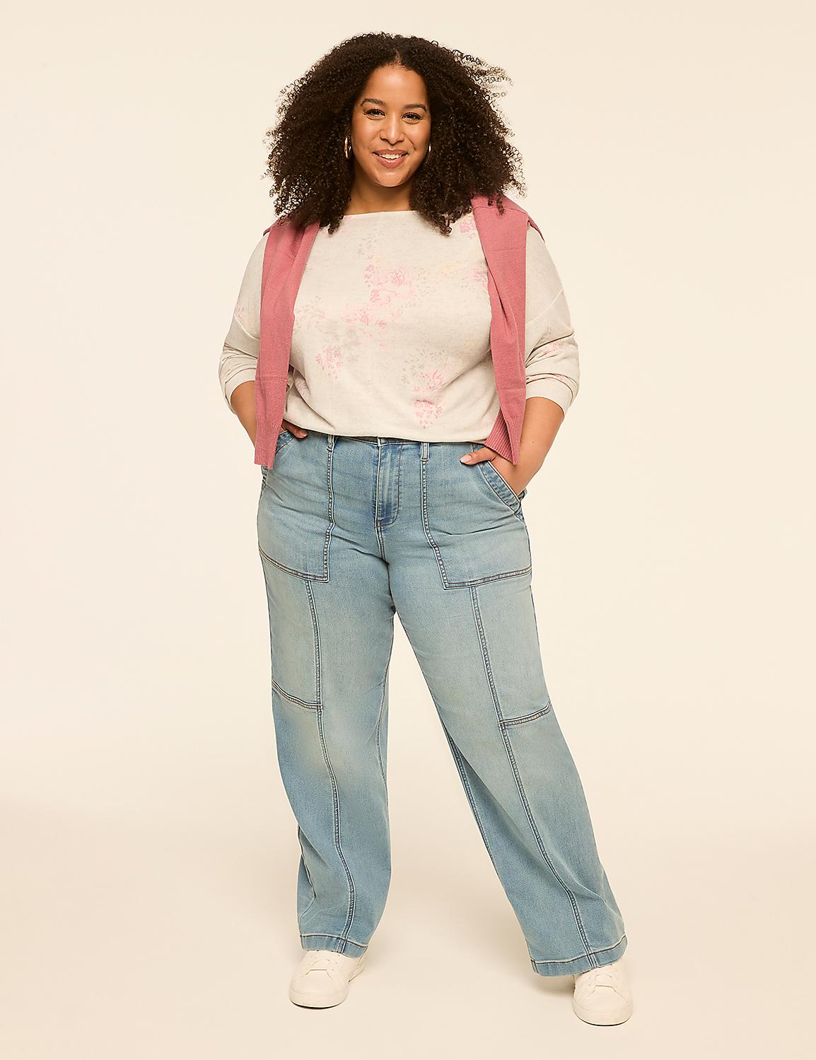 A woman with curly hair stands in the foreground wearing a light-colored sweater, a pink vest, and light-wash jeans against a plain, light-colored background. Product Image 3