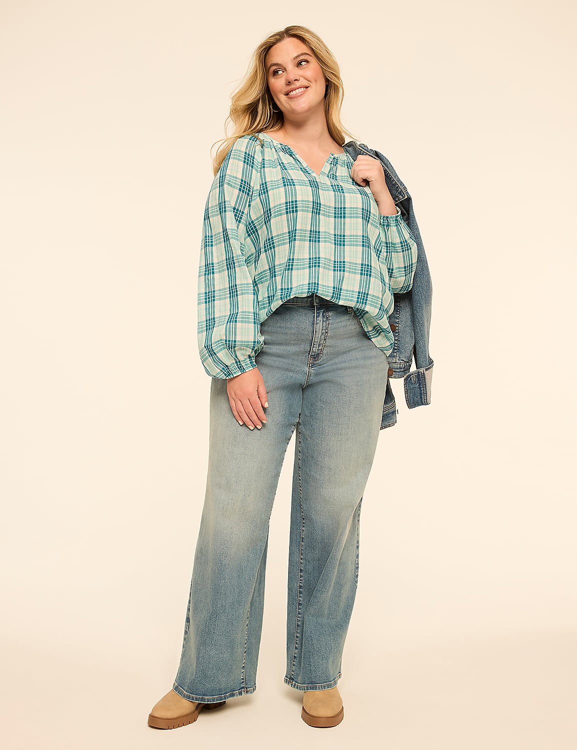 A woman in a plaid top and jeans stands against a plain, light-colored background, with a denim jacket draped over her shoulder. Product Image 3