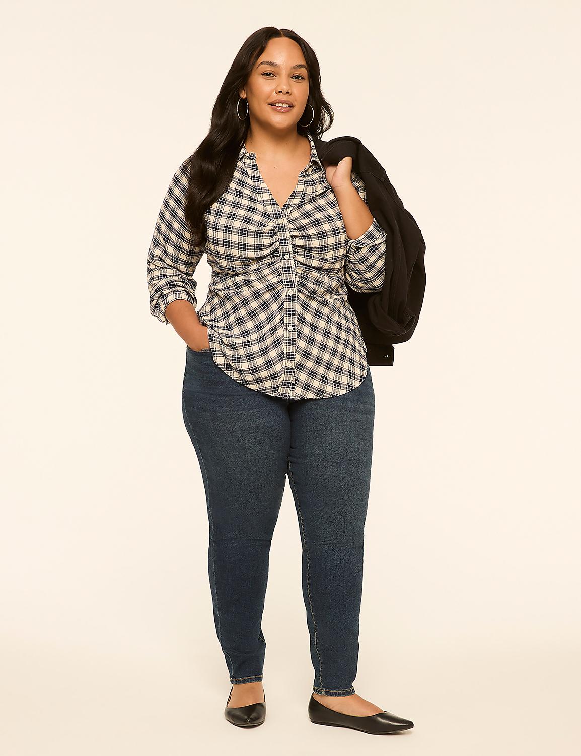 A woman in a plaid shirt and jeans stands against a plain, light-colored background, with a jacket draped over her shoulder. Product Image 3