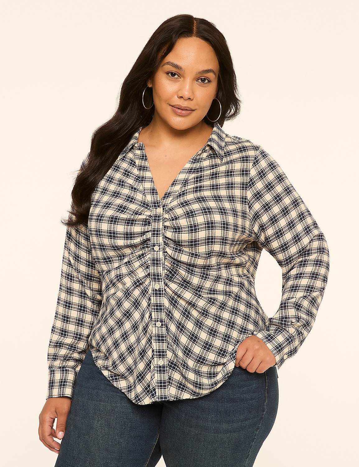 A woman in a plaid shirt and jeans stands against a plain, light-colored background. Product Image 1