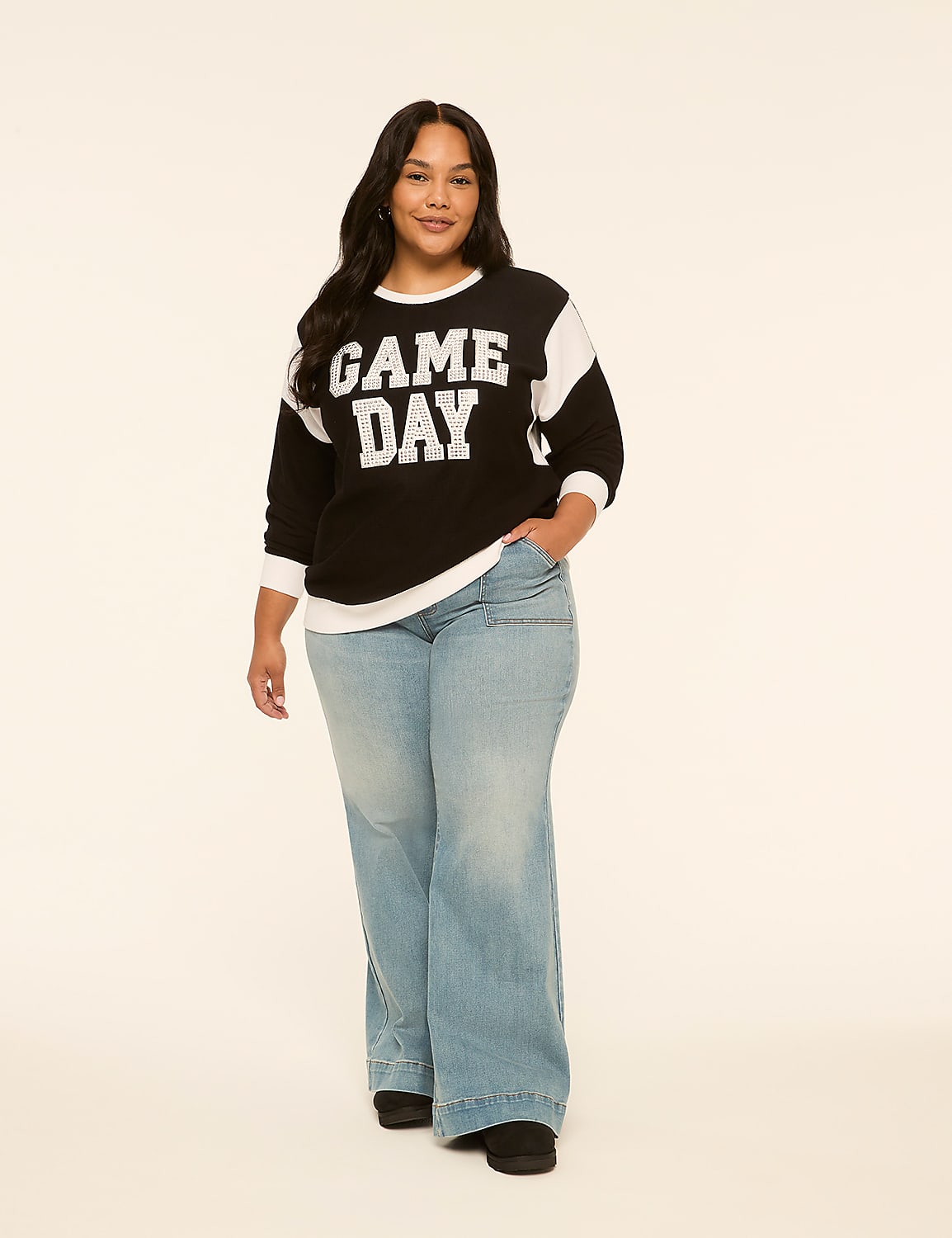 A woman in a "GAME DAY" sweatshirt and wide-leg jeans stands against a plain, light-colored background. Product Image 3