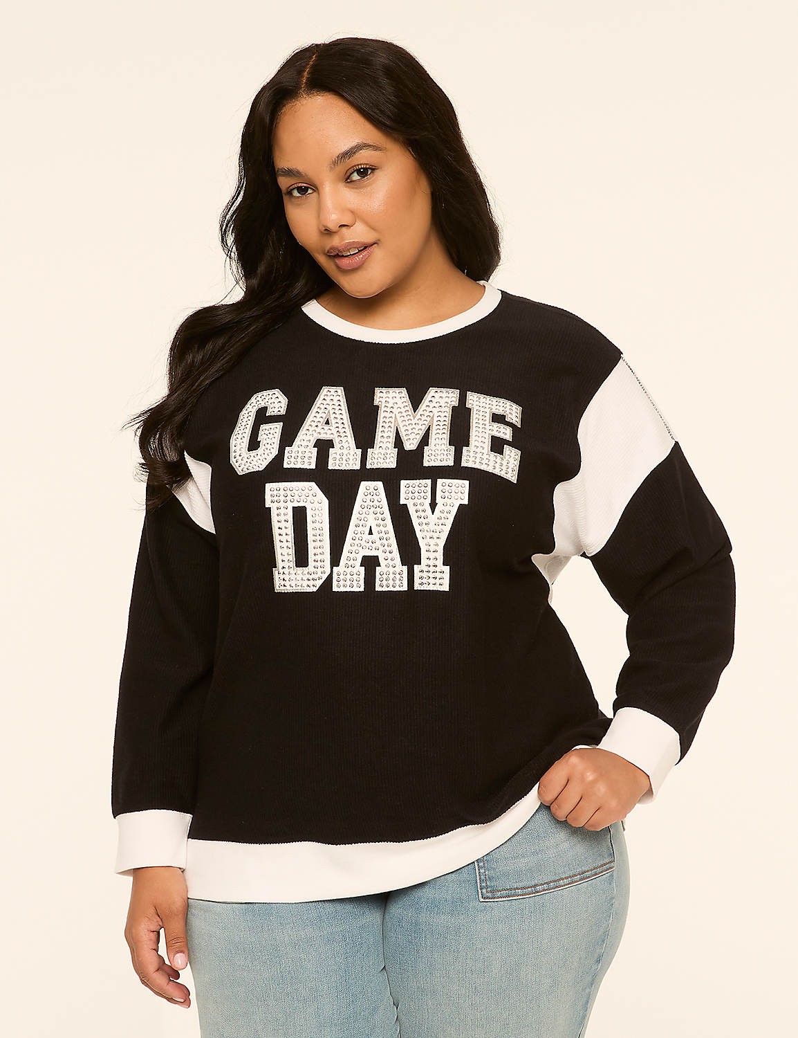A woman in a black and white "GAME DAY" sweatshirt and jeans stands against a plain, light-colored background. Product Image 1