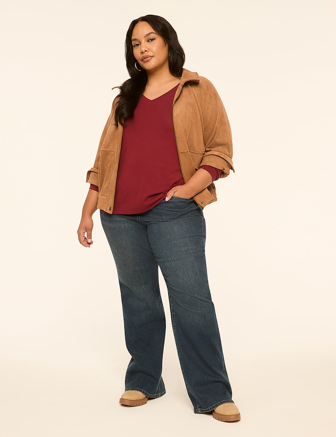 A woman in a maroon top, brown jacket, and blue jeans stands against a plain, light-colored background. Product Image 3