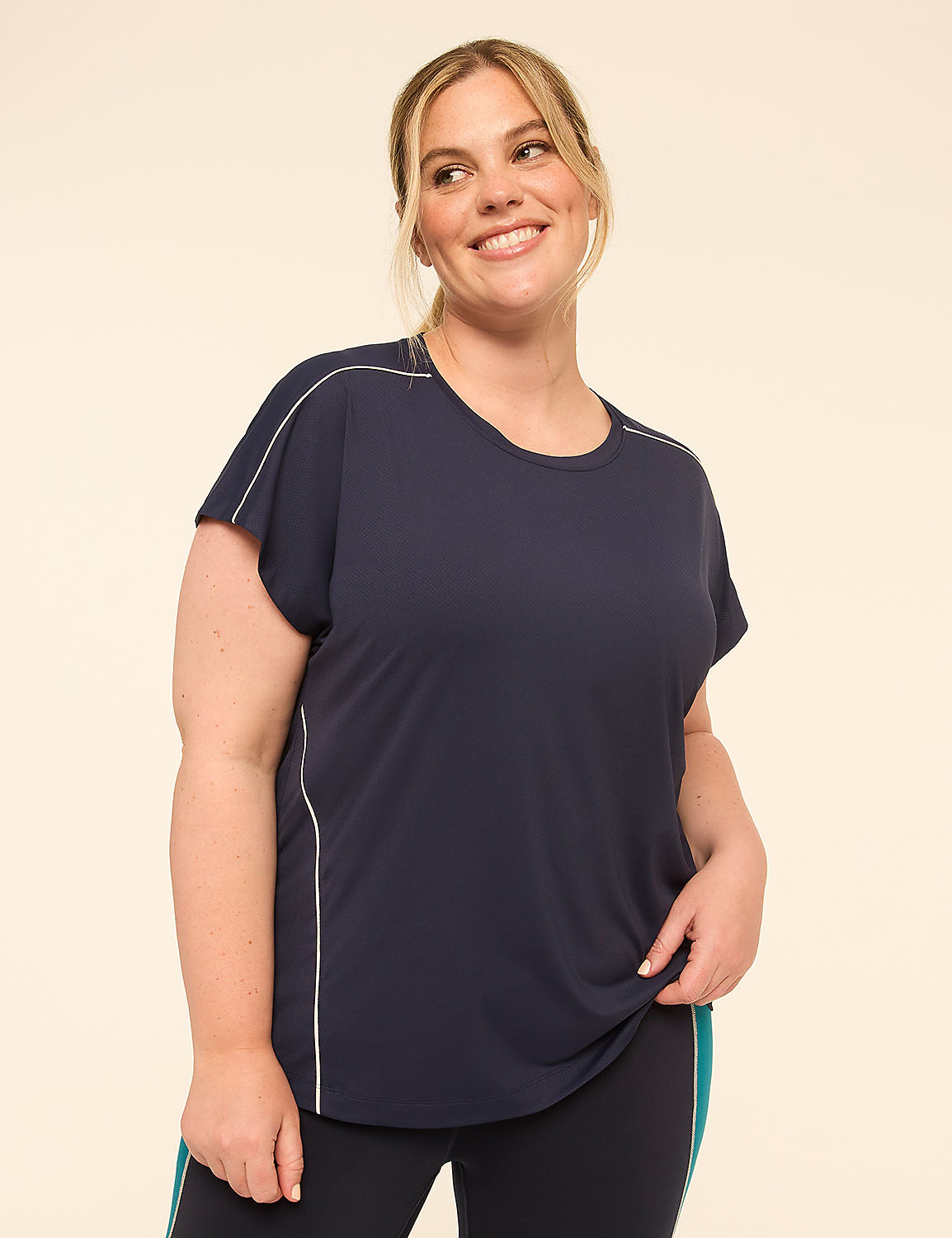 A smiling woman in a navy blue t-shirt stands against a plain, light-colored background. Product Image 1