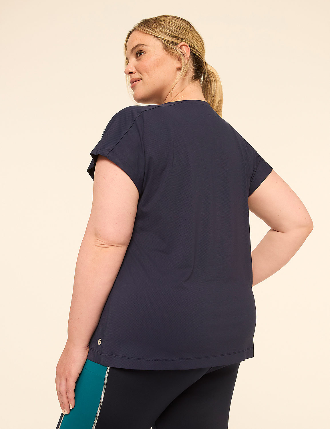 A woman in a navy t-shirt and leggings stands against a plain, light-colored background. Product Image 2