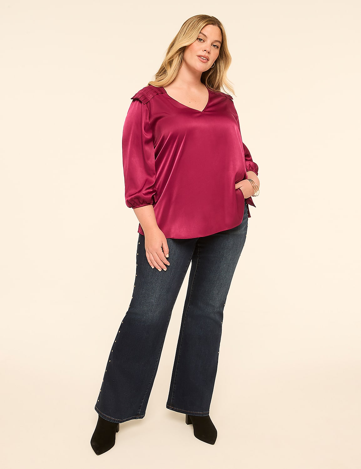 A woman in a magenta satin blouse and dark wash flared jeans stands against a plain cream background. Product Image 3