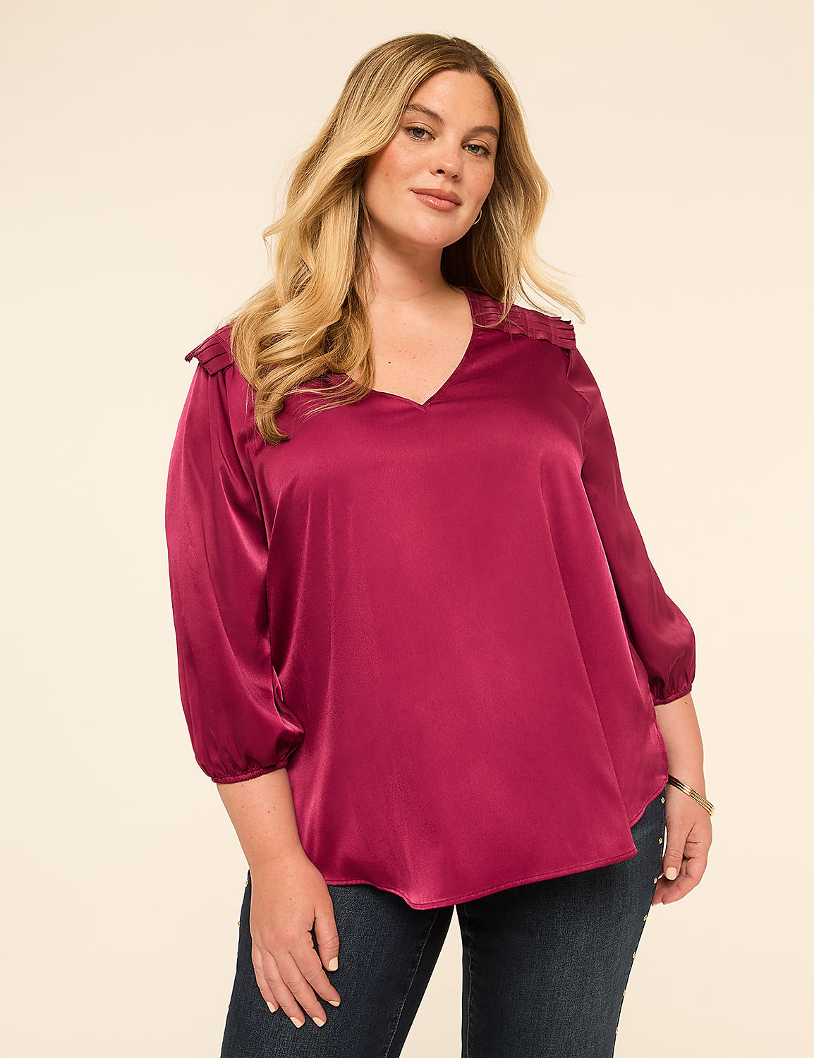 A woman in a magenta blouse and jeans stands against a plain, light-colored background. Product Image 1