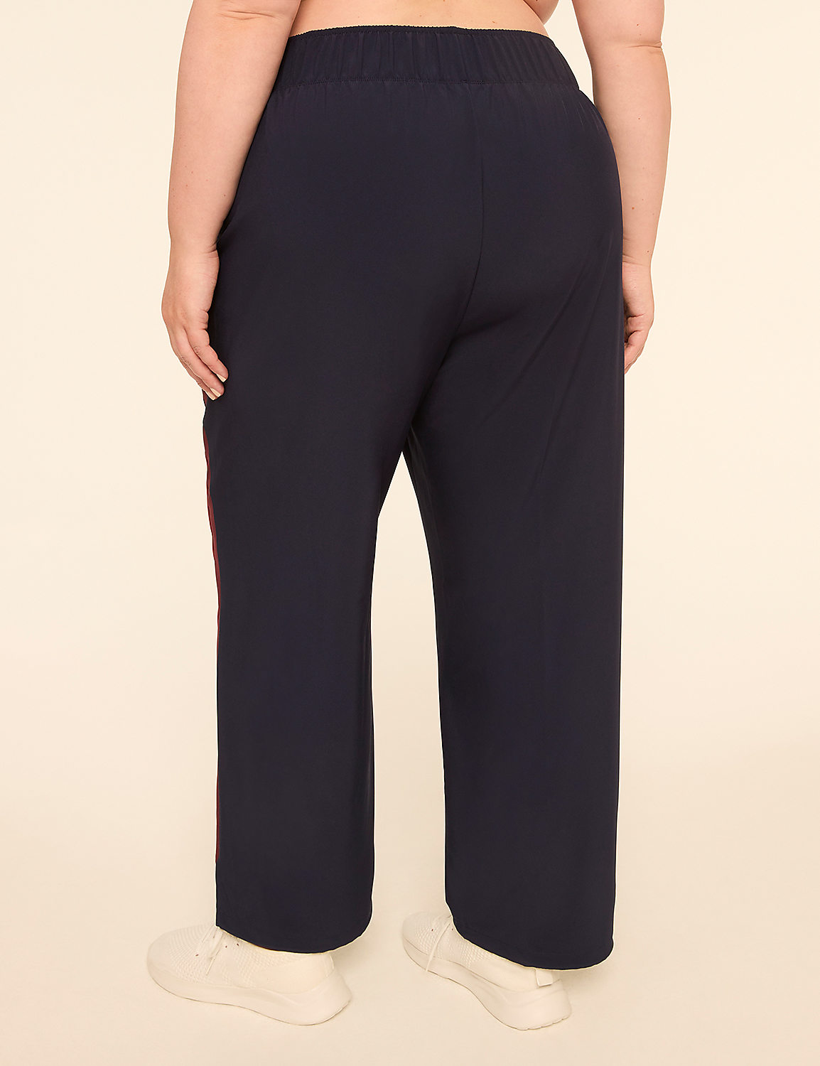 A person wearing dark blue pants with a red stripe down the side stands against a plain, light-colored background. Product Image 2