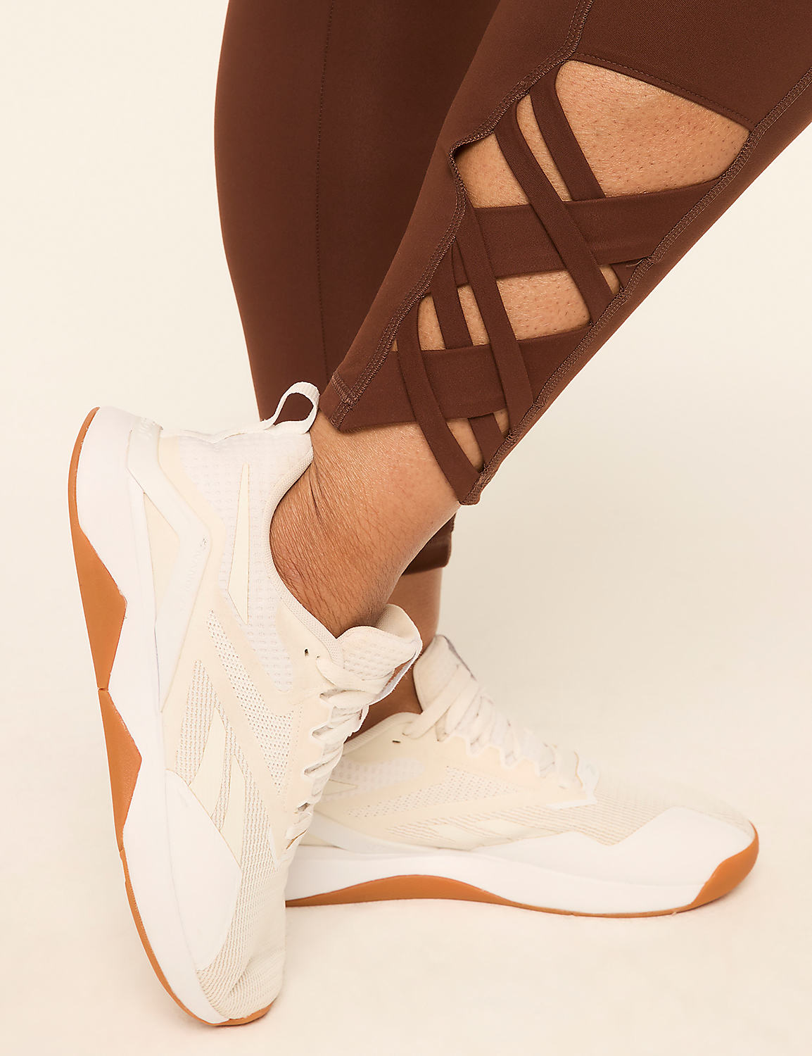 White athletic shoes with gum soles are worn with brown leggings featuring a lattice design on the calves, set against a plain cream background. Product Image 5