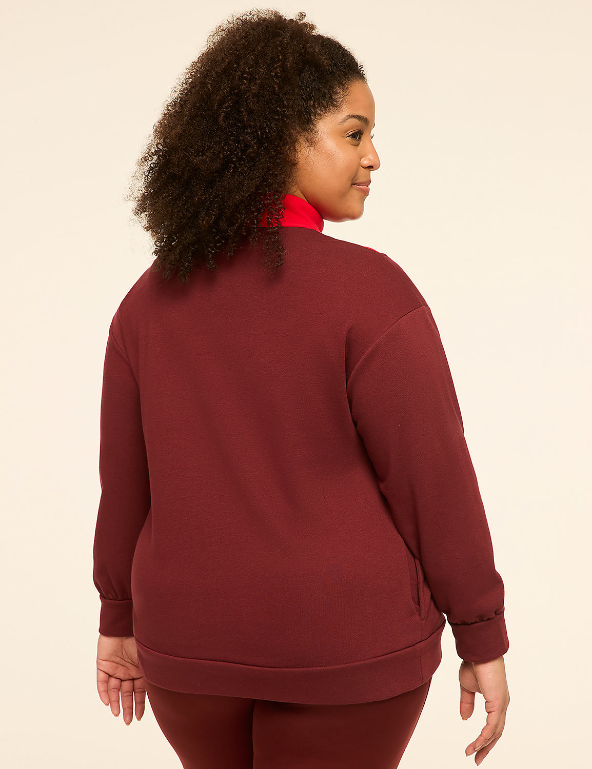 A woman in a maroon sweatshirt and red turtleneck stands against a plain, light-colored background. Product Image 2