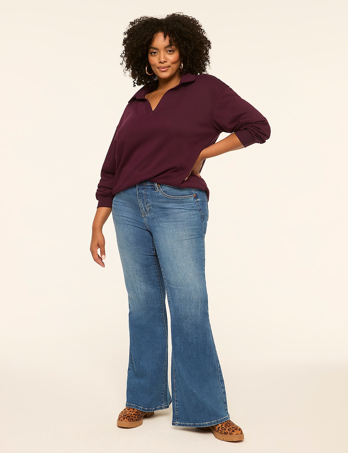 A woman in a maroon collared shirt and flared jeans stands against a plain, light-colored background. Product Image 3