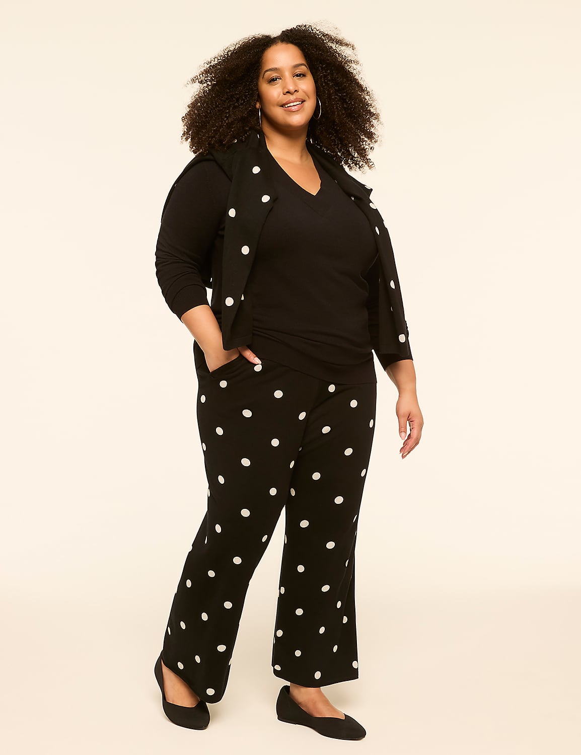 A woman in a black polka-dot outfit stands against a plain, light-colored background. Product Image 3