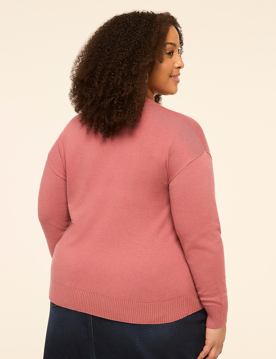 A woman in a pink sweater and dark skirt stands against a plain, light-colored background. Product Image 2
