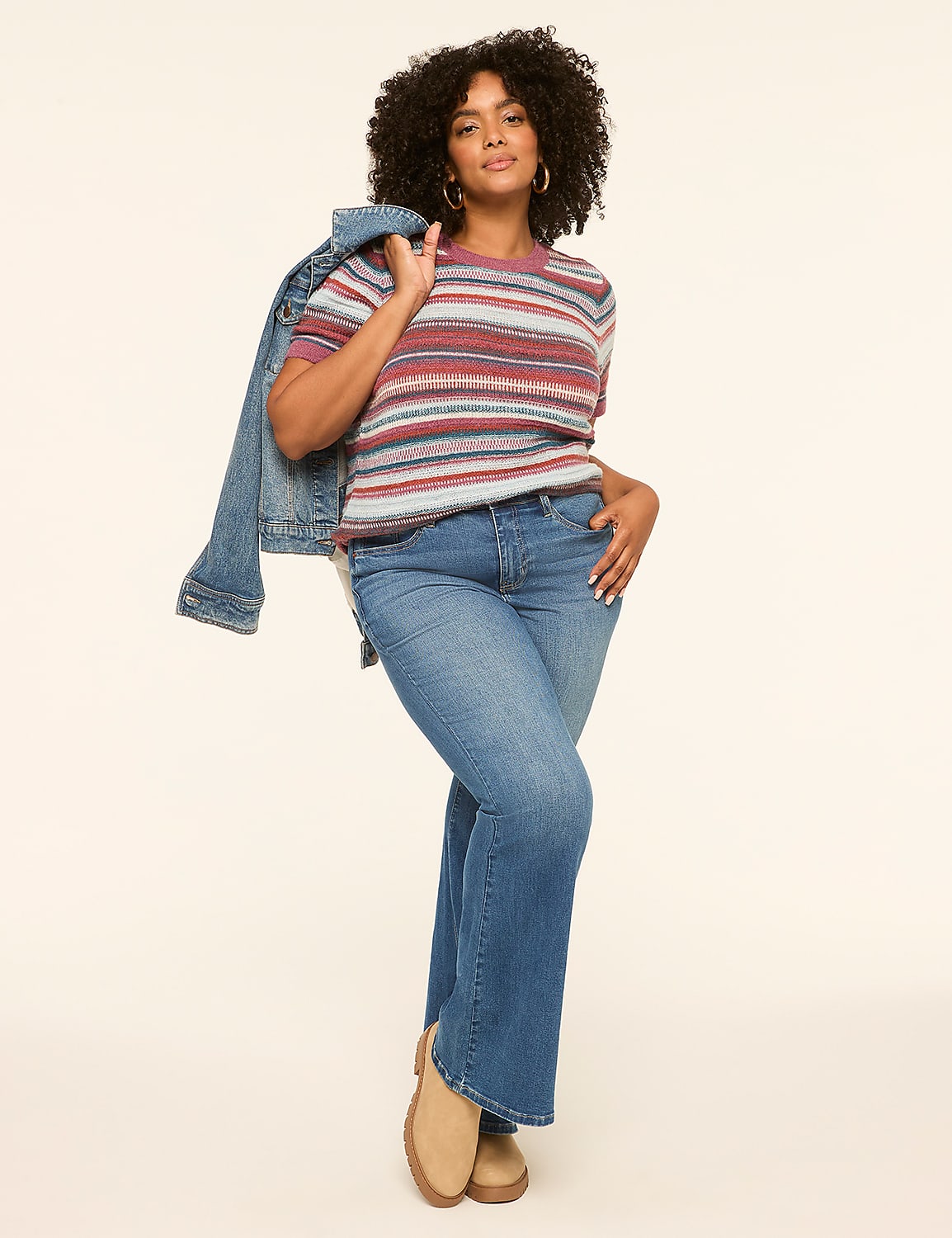 A woman in a striped shirt and jeans poses with a denim jacket draped over her shoulder against a plain, light-colored background. Product Image 3