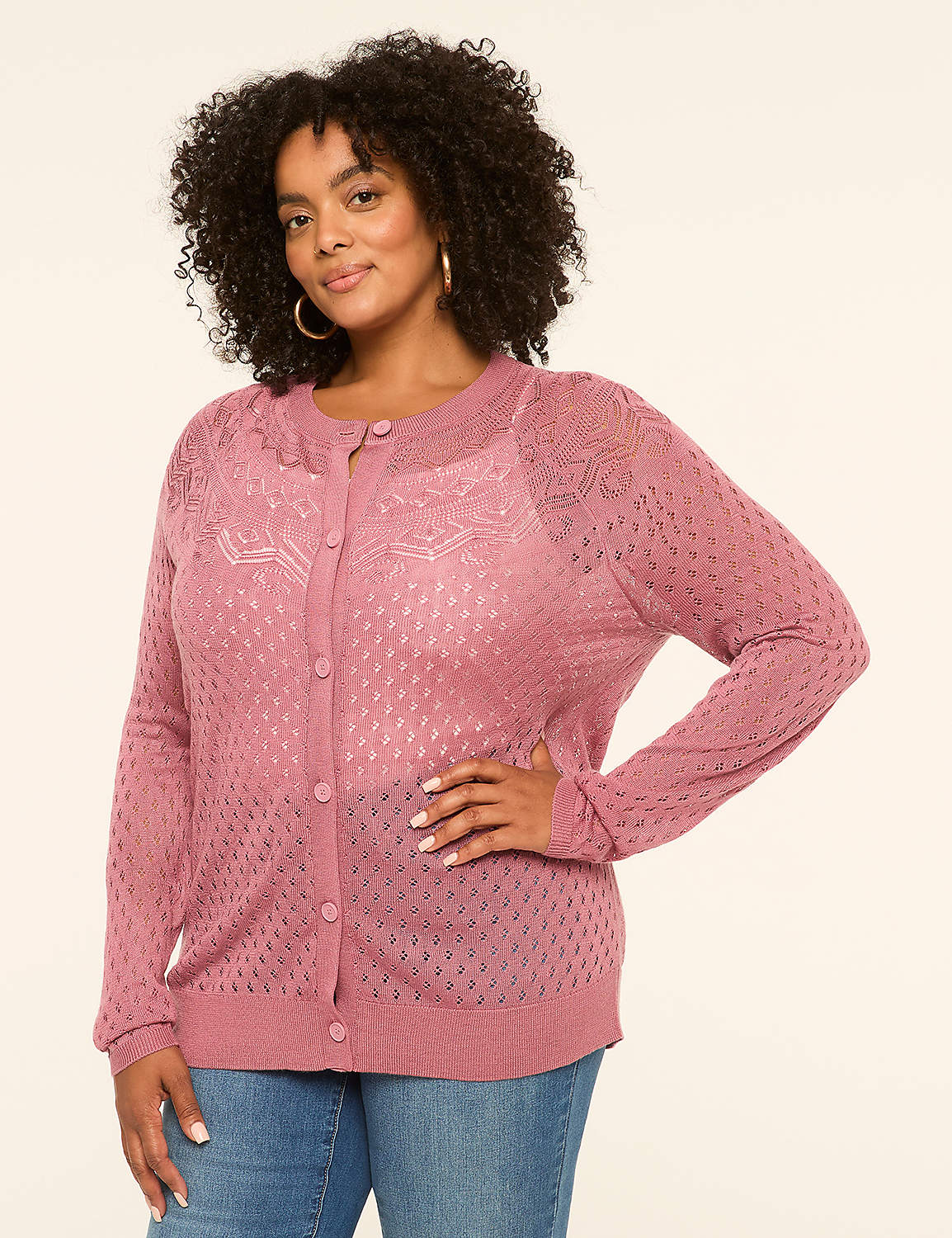 A woman in a pink cardigan and jeans stands against a plain, light-colored background. Product Image 1