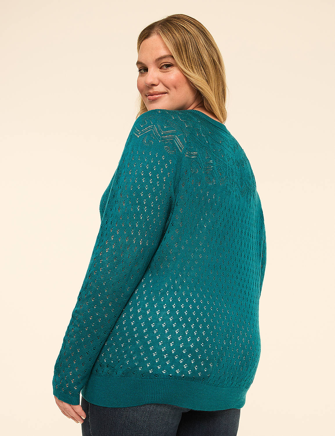 A woman in a teal, open-knit sweater turns to smile over her shoulder against a plain, light-colored background. Product Image 2