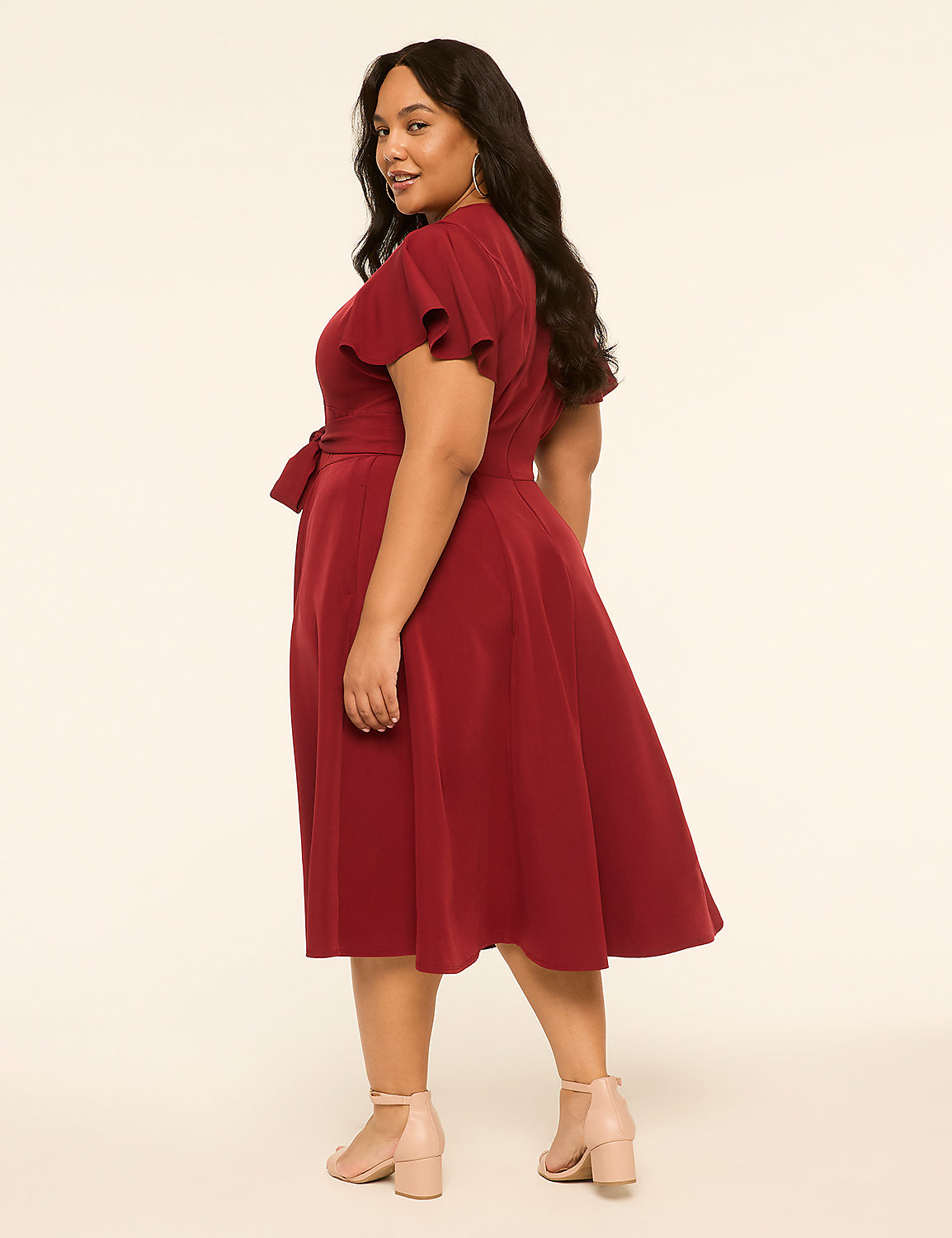 A woman in a red dress stands against a plain, light-colored background. Product Image 2