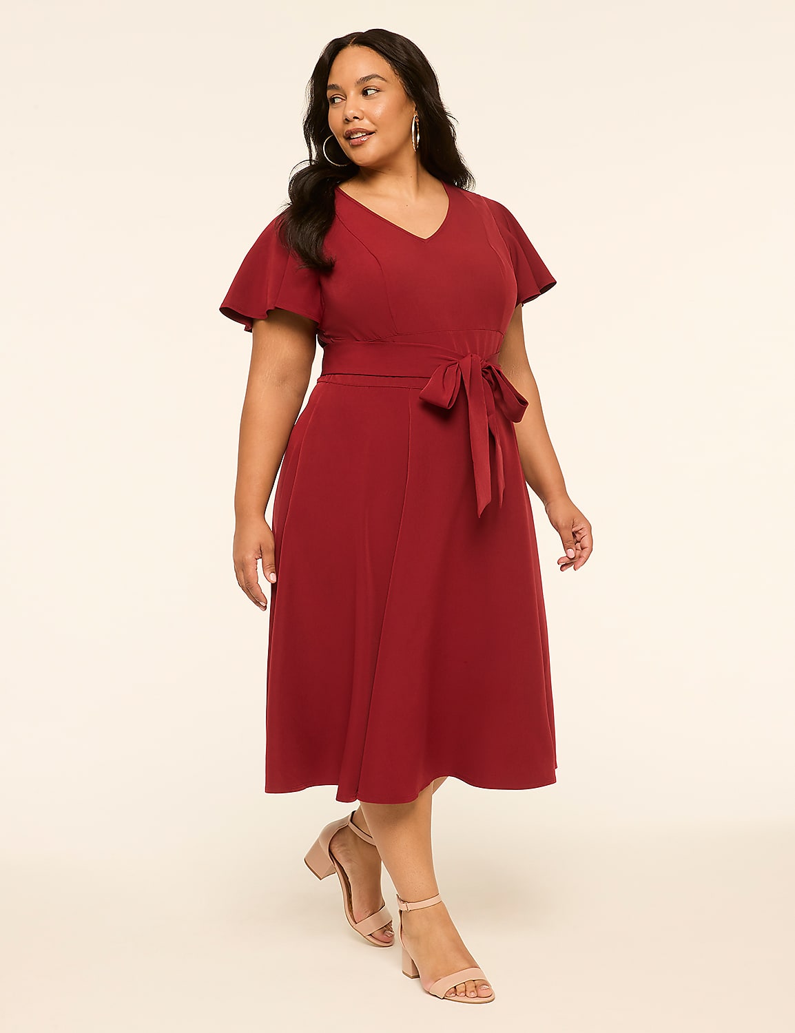A woman in a red dress stands against a plain, light-colored background. Product Image 1