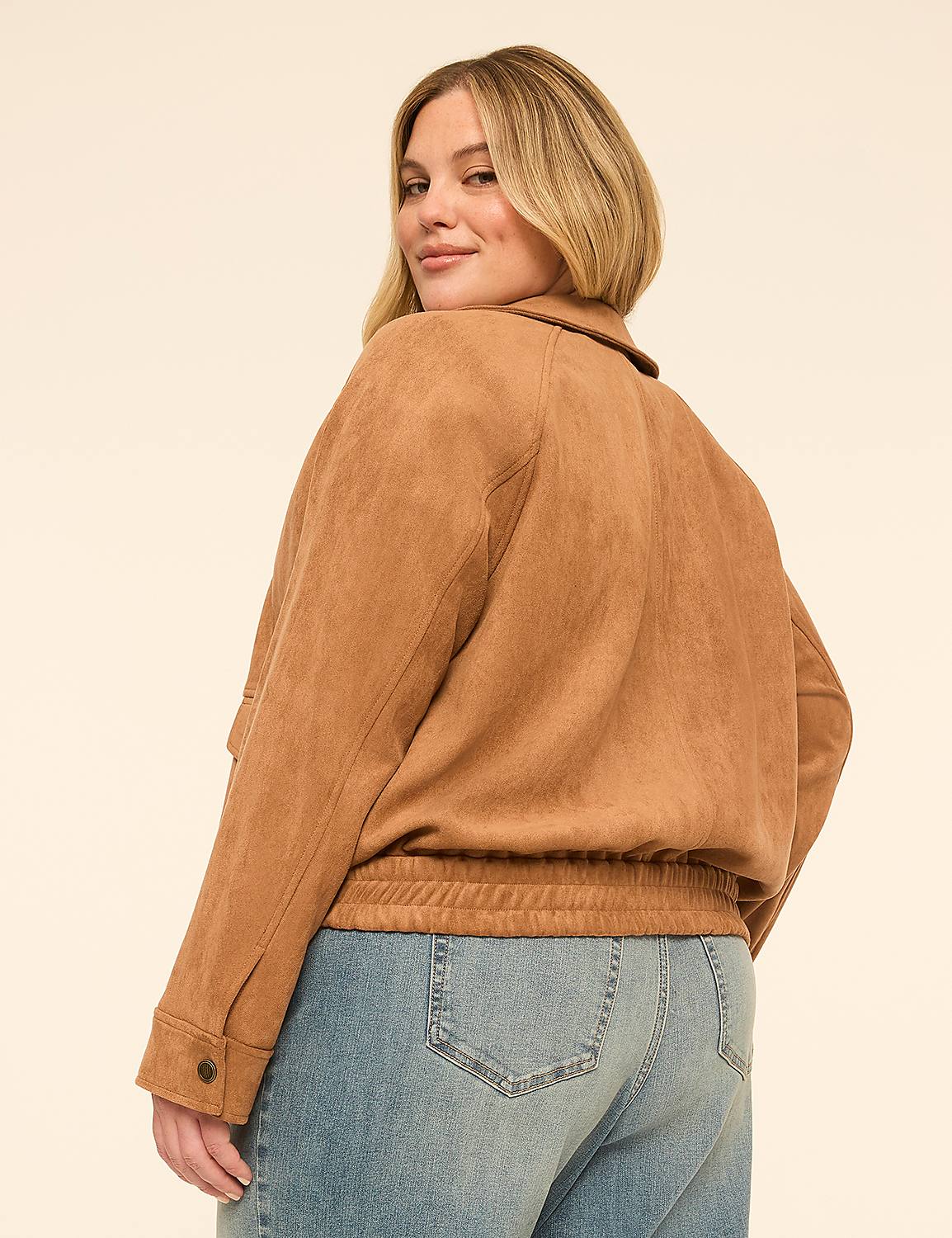 A woman in a tan jacket and blue jeans poses against a plain, light-colored background. Product Image 2