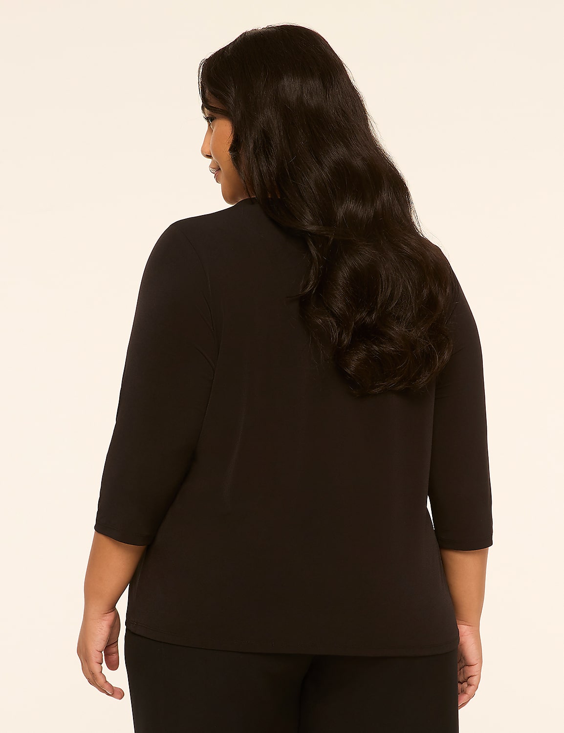 A woman with long, dark hair stands facing away from the camera in a black top and pants against a plain, light-colored background. Product Image 2
