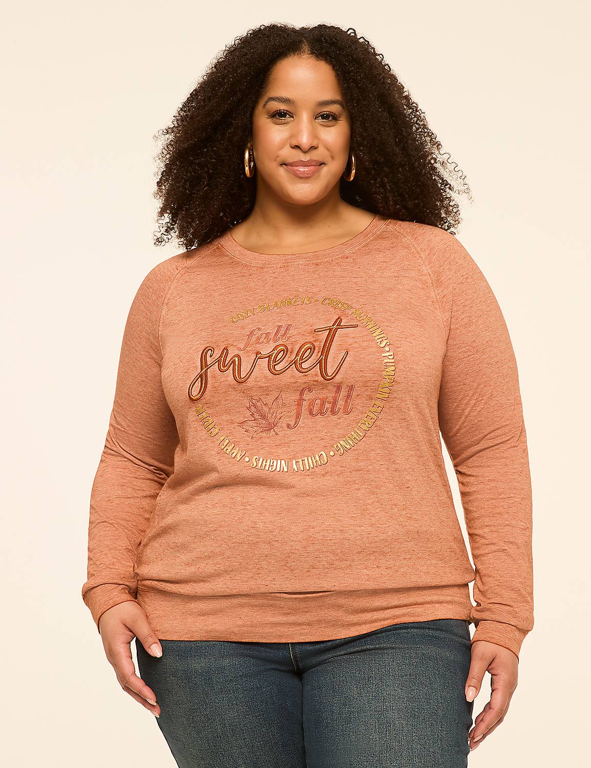 A woman with curly hair smiles at the camera, wearing a rust-colored sweatshirt with a circular graphic that says "fall is sweet fall," against a plain, light-colored background. Product Image 1