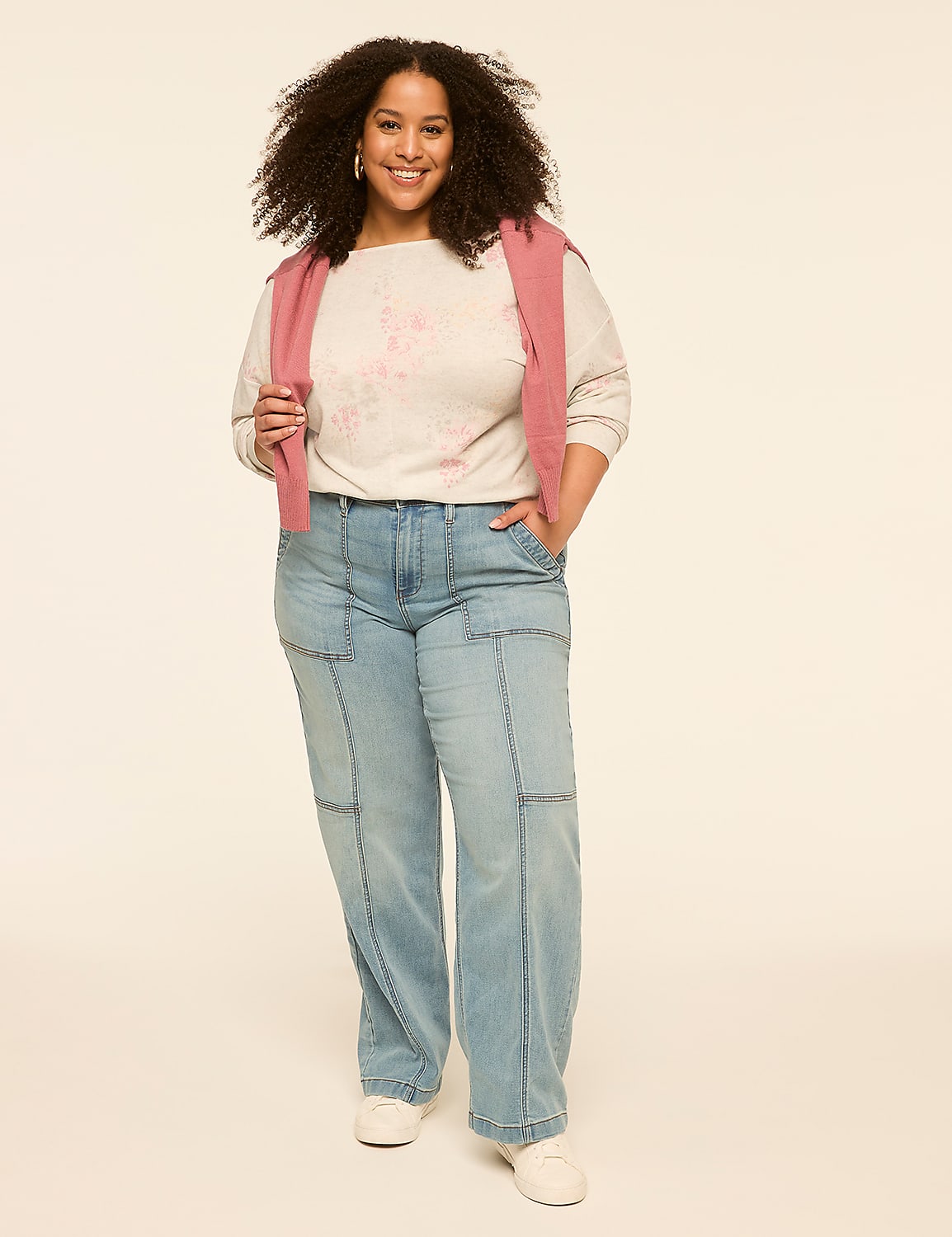 A smiling woman in a light-colored sweater and light-wash jeans stands against a plain, light-colored background. Product Image 3