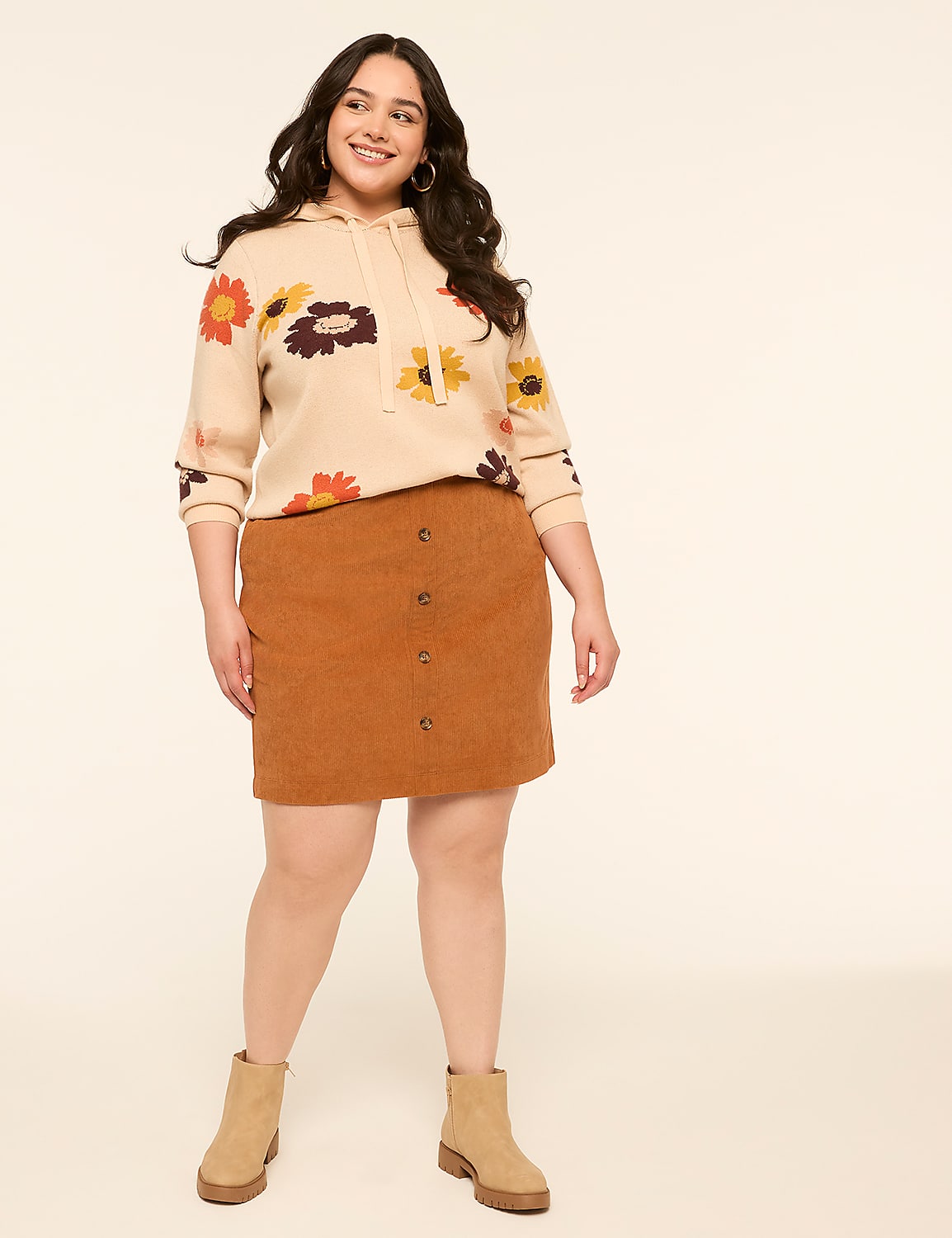 A smiling woman in a floral hoodie and corduroy skirt stands against a plain, light-colored background. Product Image 3