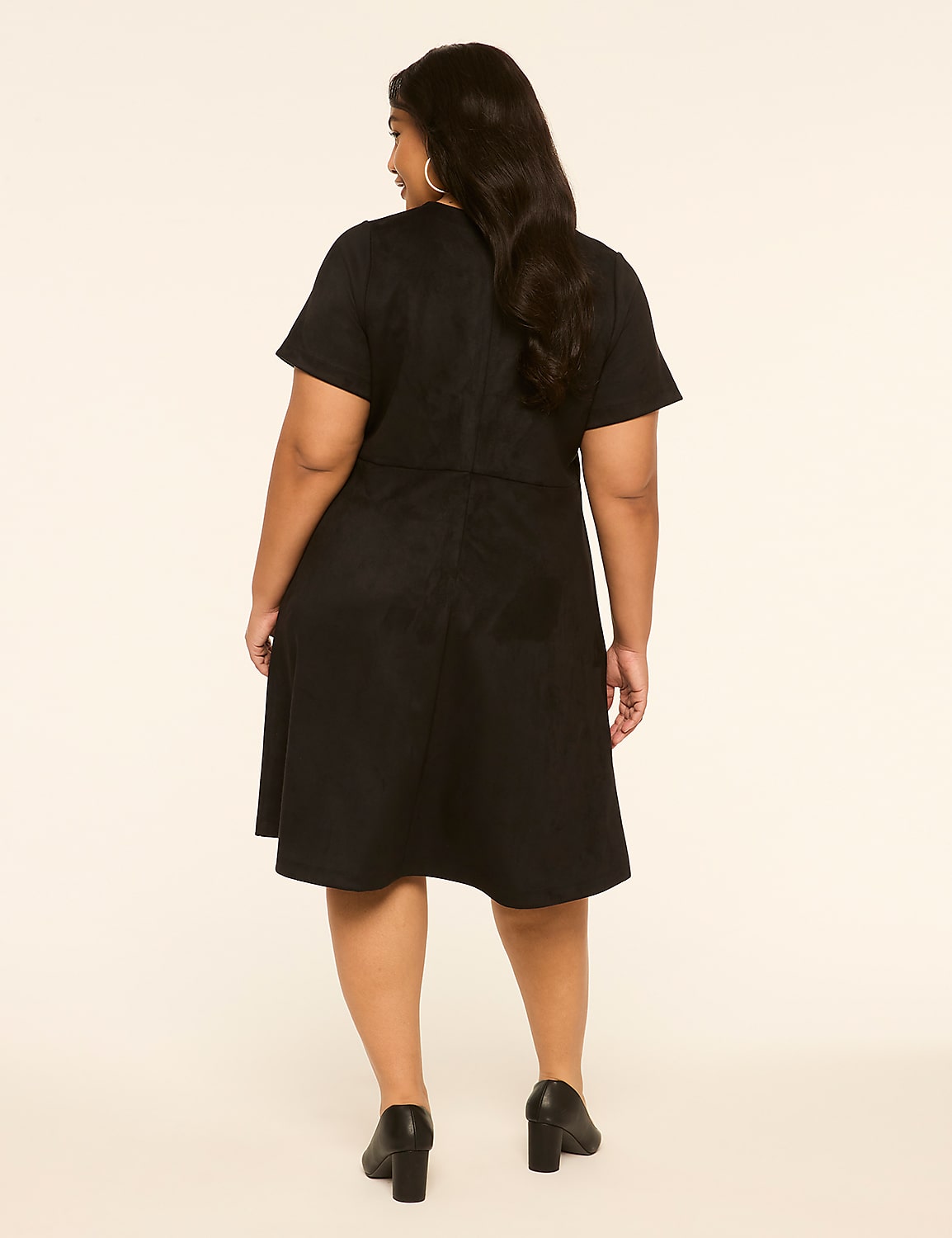 A woman in a black dress stands against a plain, light-colored background. Product Image 2