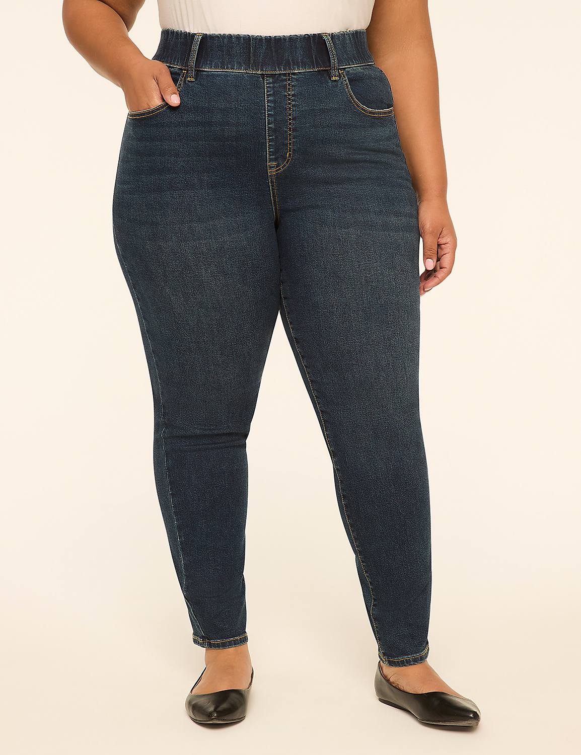 A woman in dark wash denim jeans and black ballet flats stands against a plain, light-colored background. Product Image 1