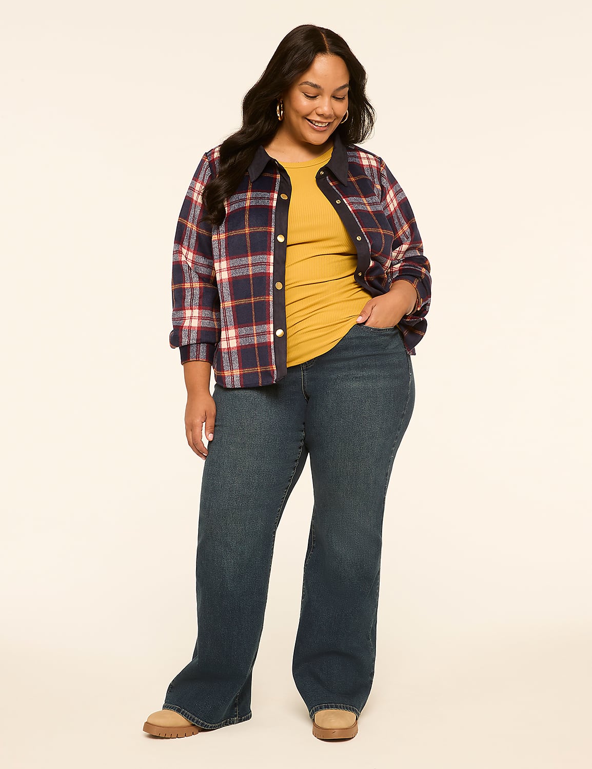 A smiling woman in a plaid shirt and jeans stands against a plain, light-colored background. Product Image 3