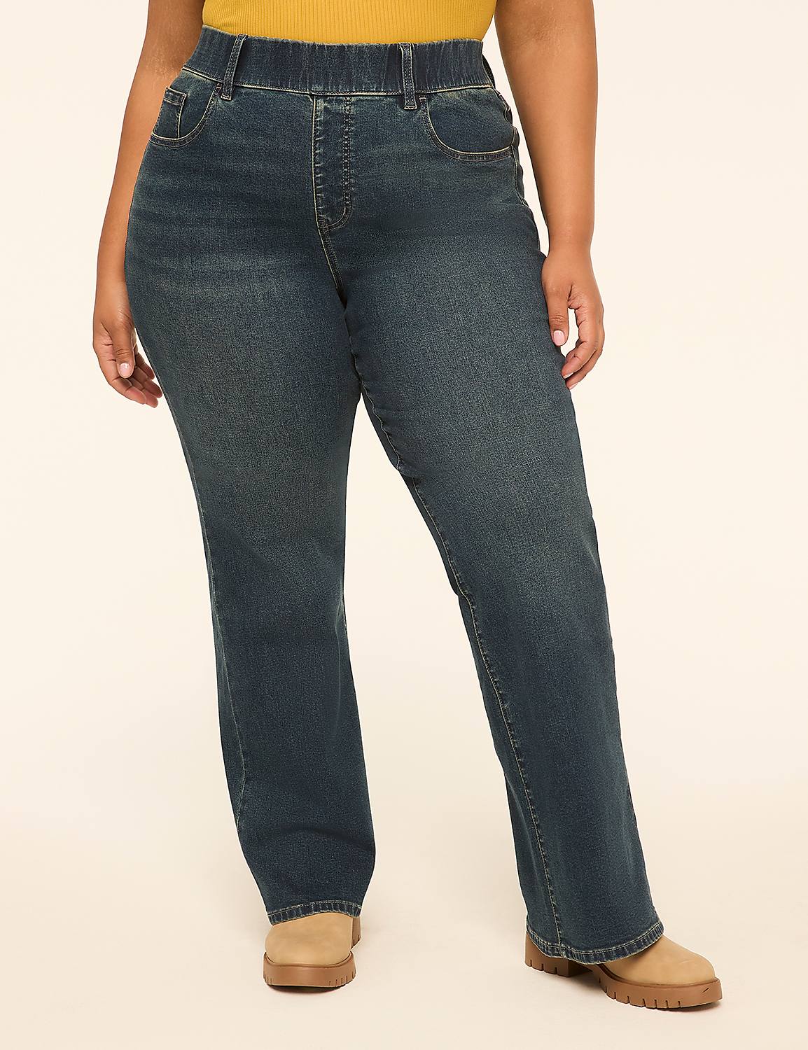 A person wearing dark wash denim jeans and tan shoes stands against a plain, light-colored background. Product Image 1