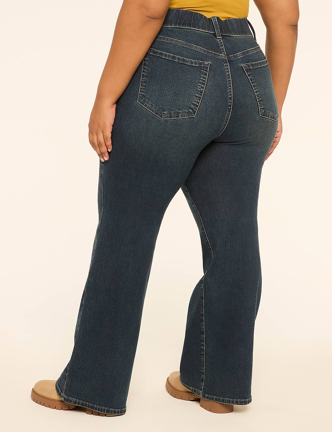 A person wearing dark wash flare jeans and tan shoes stands against a plain, light-colored background. Product Image 2