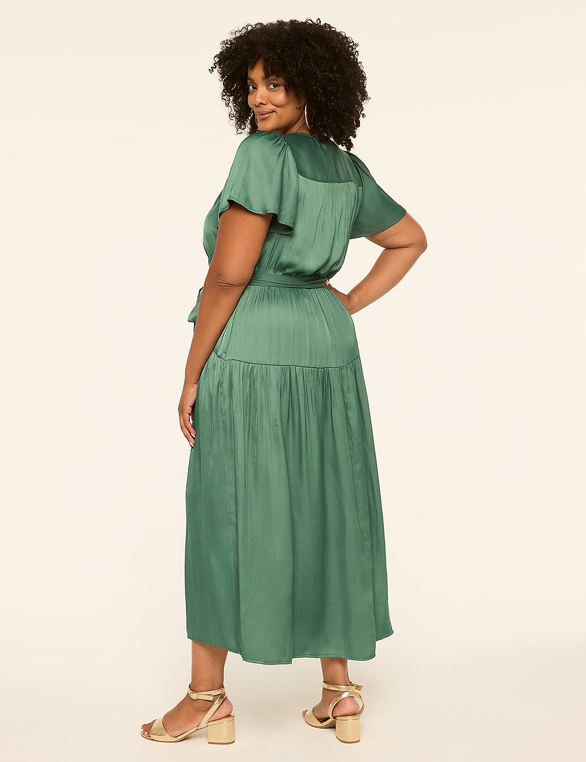 A woman in a green dress stands against a plain, light-colored background. Product Image 2