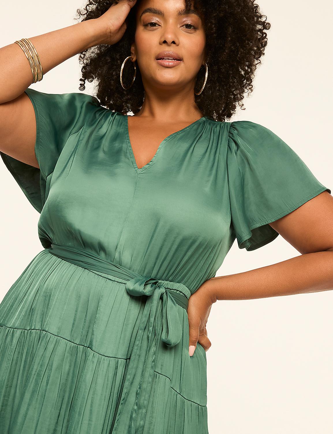 A woman in a green satin dress with flutter sleeves and a tie waist stands against a plain, light-colored background. Product Image 3