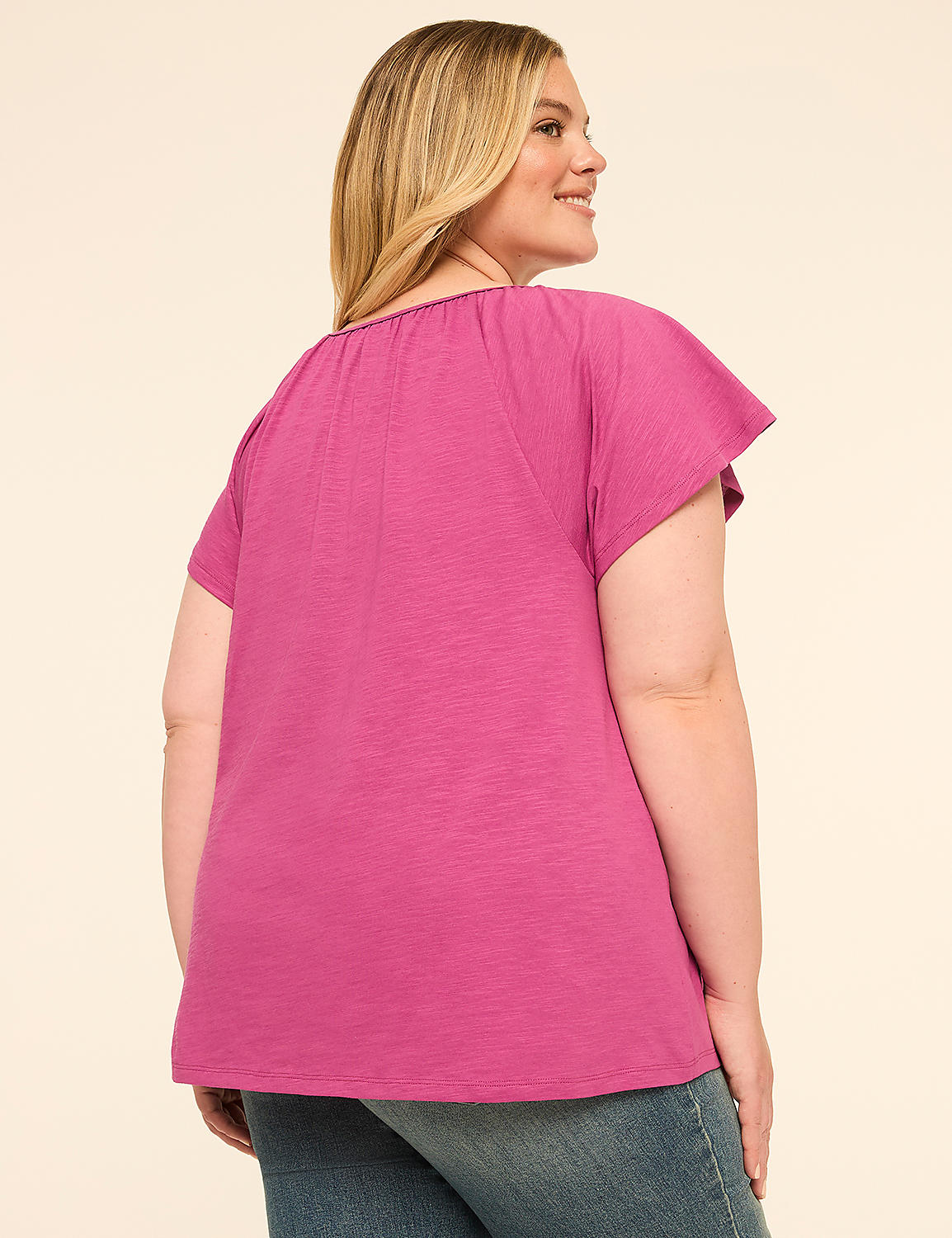 A woman in a pink top and blue jeans stands against a plain, light-colored background. Product Image 2