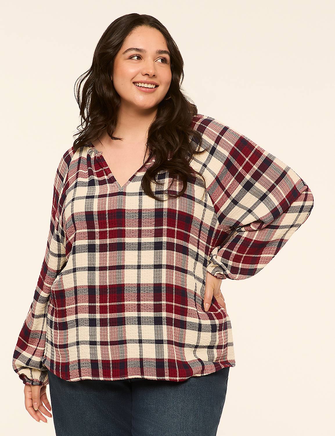 A smiling woman in a plaid blouse and jeans stands against a plain, light-colored background. Product Image 1