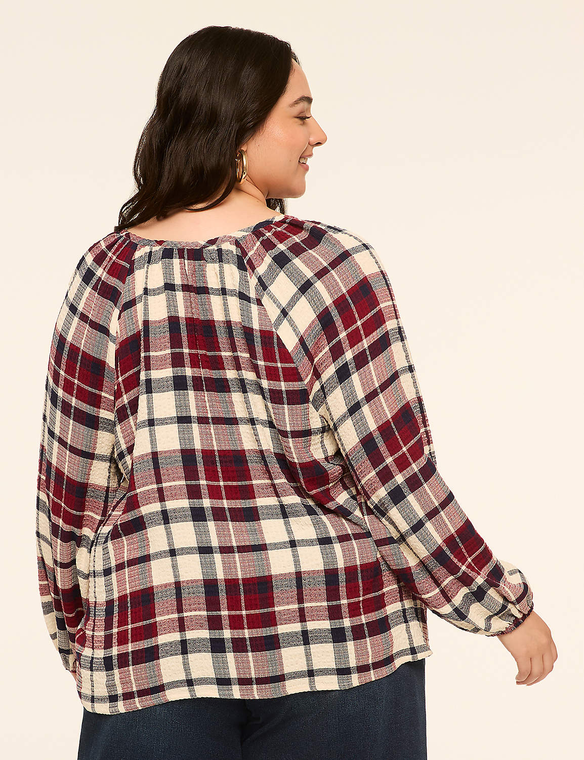 A woman in a red, white, and blue plaid shirt stands against a plain, light-colored background. Product Image 2