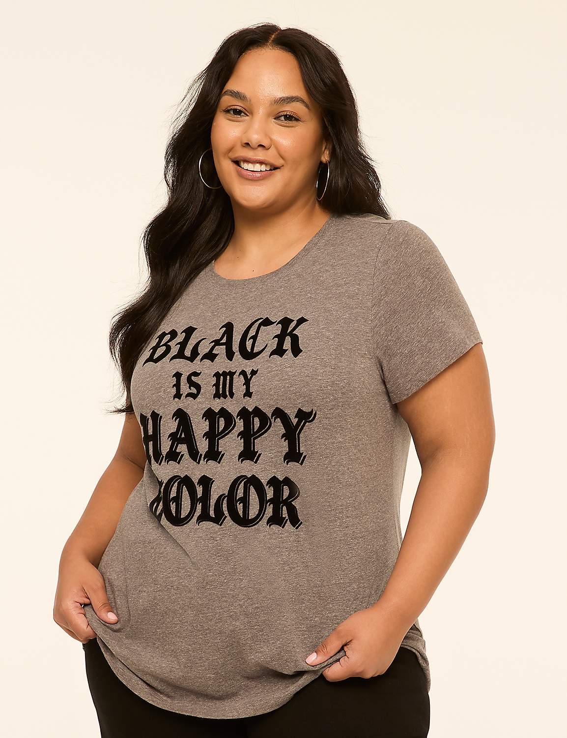 A smiling woman in a grey t-shirt with the words "BLACK IS MY HAPPY COLOR" stands against a plain, light-colored background. Product Image 1