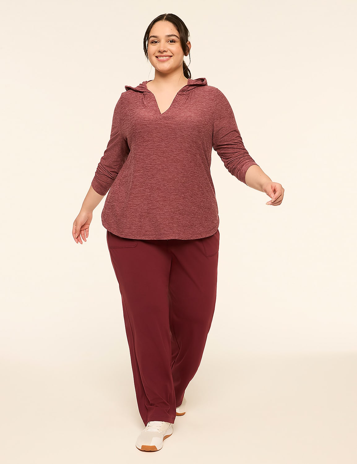 A smiling woman in a maroon hoodie and pants walks forward against a plain, light-colored background. Product Image 3