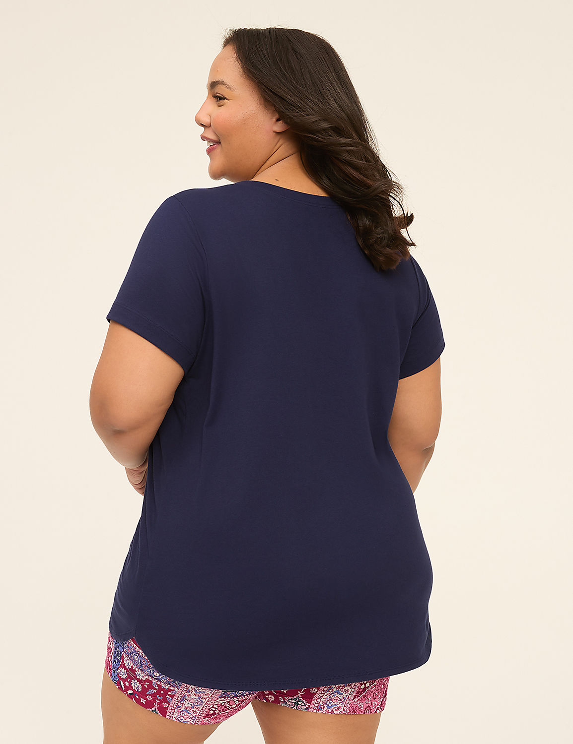 A woman in a navy blue t-shirt and patterned shorts stands against a plain, light-colored background. Product Image 2