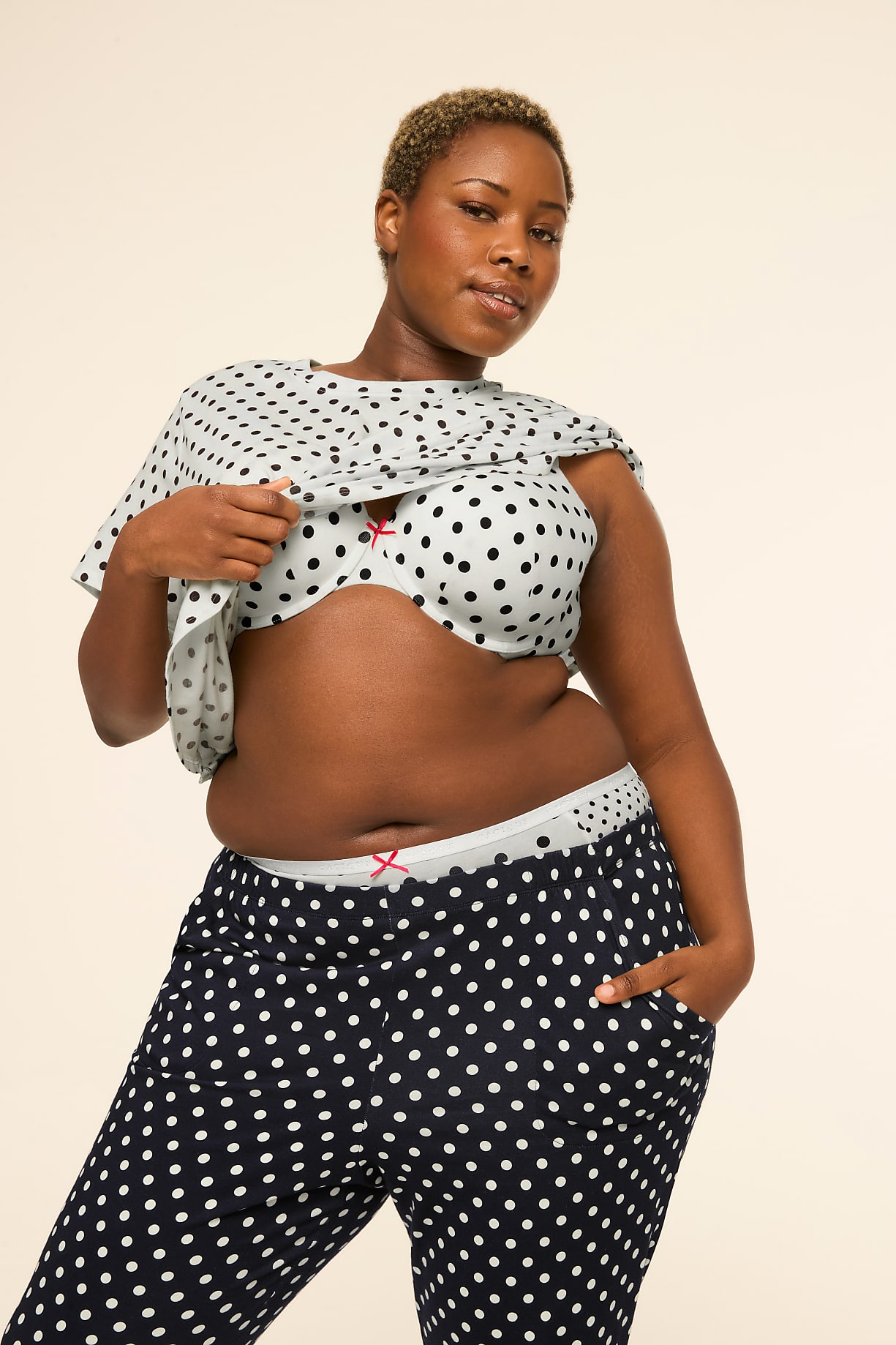 A woman in polka dot pajamas stands against a plain, light background. Product Image 9