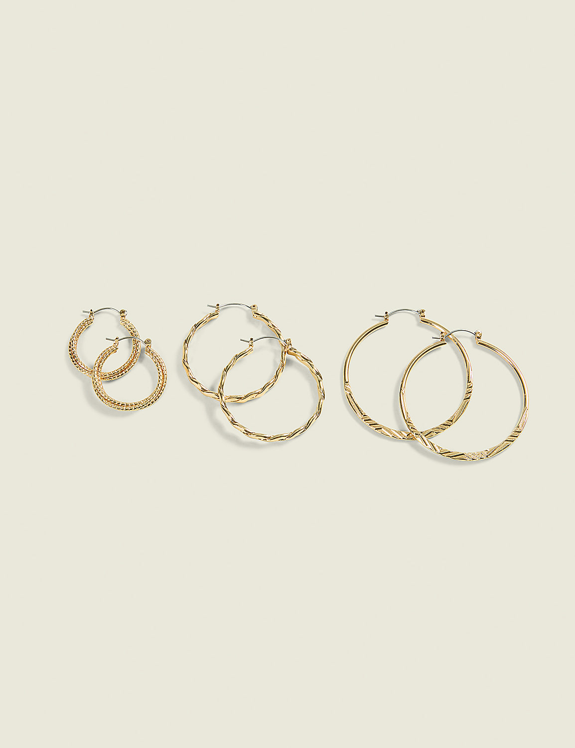 Three pairs of gold hoop earrings, varying in size and texture, are arranged on a plain, light-colored background. Product Image 1